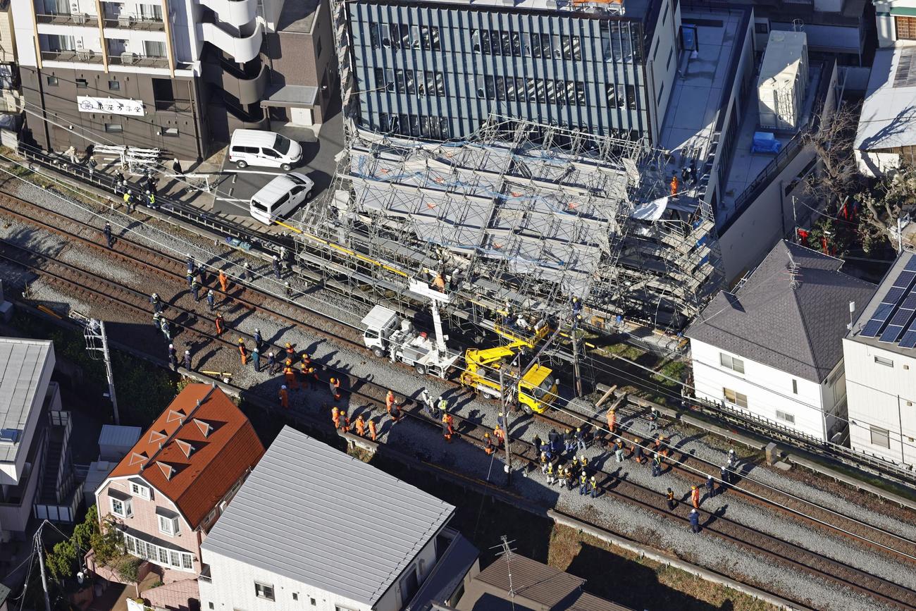 東急東横線、自由が丘駅付近の線路脇で起きたビル建設現場の足場崩落事故で、復旧作業にあたる作業員ら（共同）