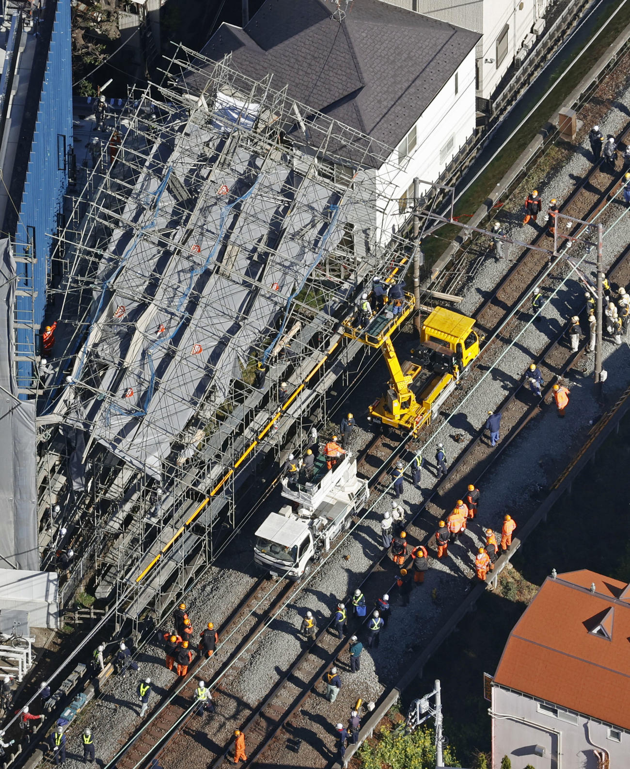 東急東横線、自由が丘駅付近の線路脇で起きたビル建設現場の足場崩落事故で、復旧作業に当たる作業員ら（共同）
