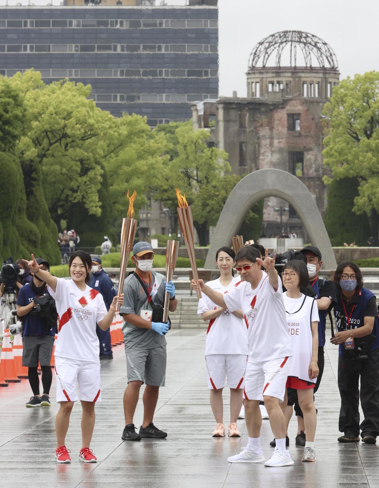 平和記念公園で行われた無観客の聖火の点火式でポーズするランナー(共同）