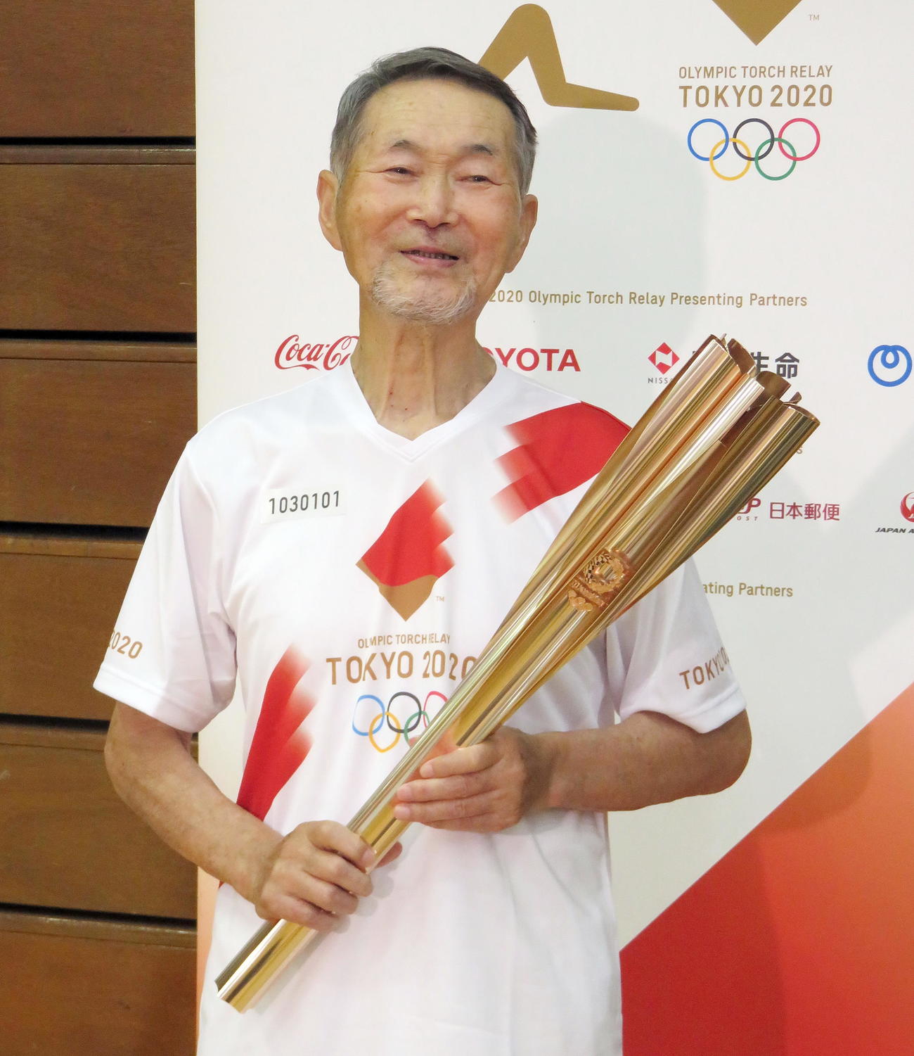 トーチを手に笑顔を見せる菅原武男さん（撮影・鎌田直秀）