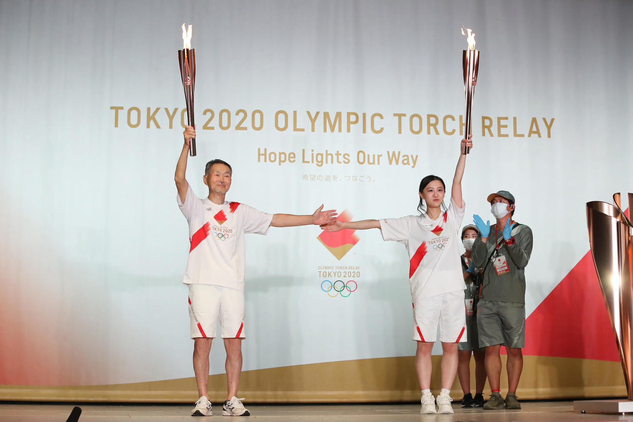 聖火ランナーを務めた元ハンマー投げ選手の菅原武男さん（左）と次走者の吉野友梨絵さん（代表撮影）