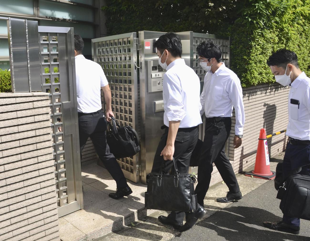 AOKIホールディングスの青木拡憲前会長が住んでいるとみられる住宅に入る東京地検特捜部の係官ら＝27日午前9時ごろ、東京都渋谷区