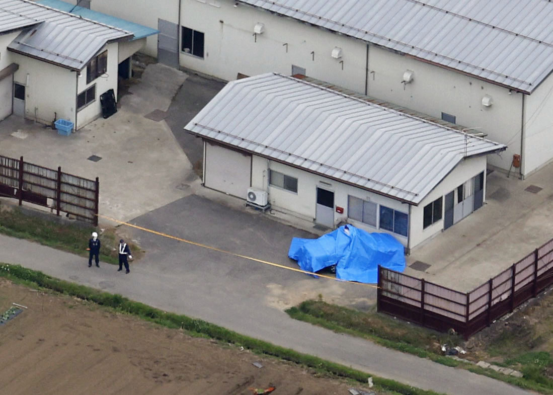 男が立てこもっていた住宅近くにある建物脇でシートがかけられたパトカー（共同）