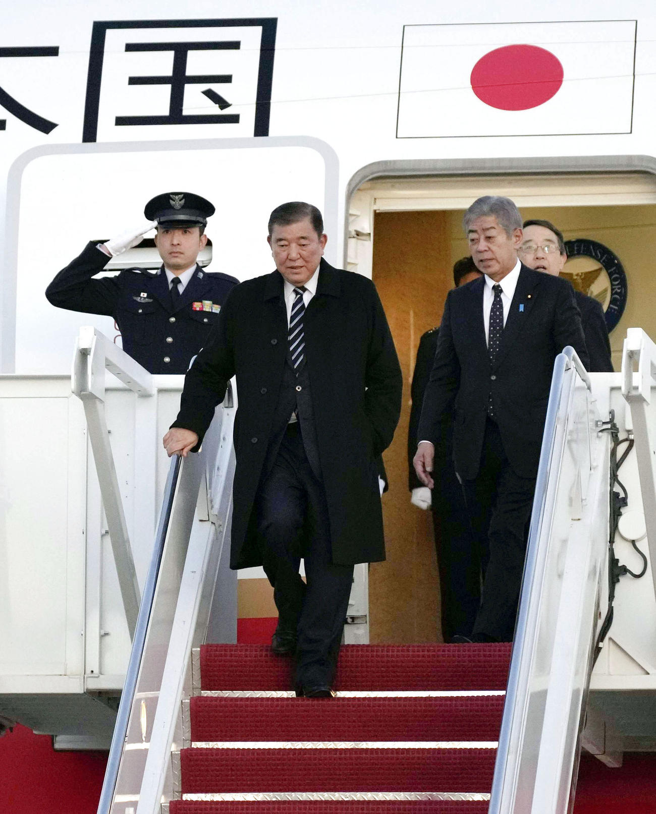 日米首脳会談のため、ワシントン郊外のアンドルーズ空軍基地に到着した石破首相。右隣は岩屋外相＝6日（共同）