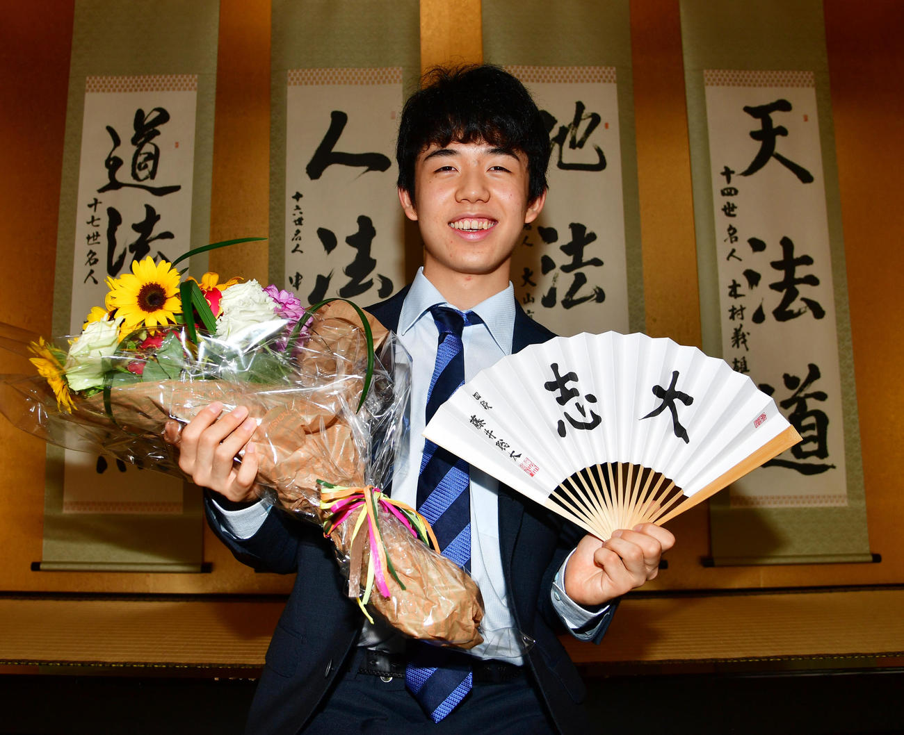 歴代1位タイとなる28連勝を飾り花束を手に笑顔を見せる藤井聡太四段（2017年6月21日撮影）