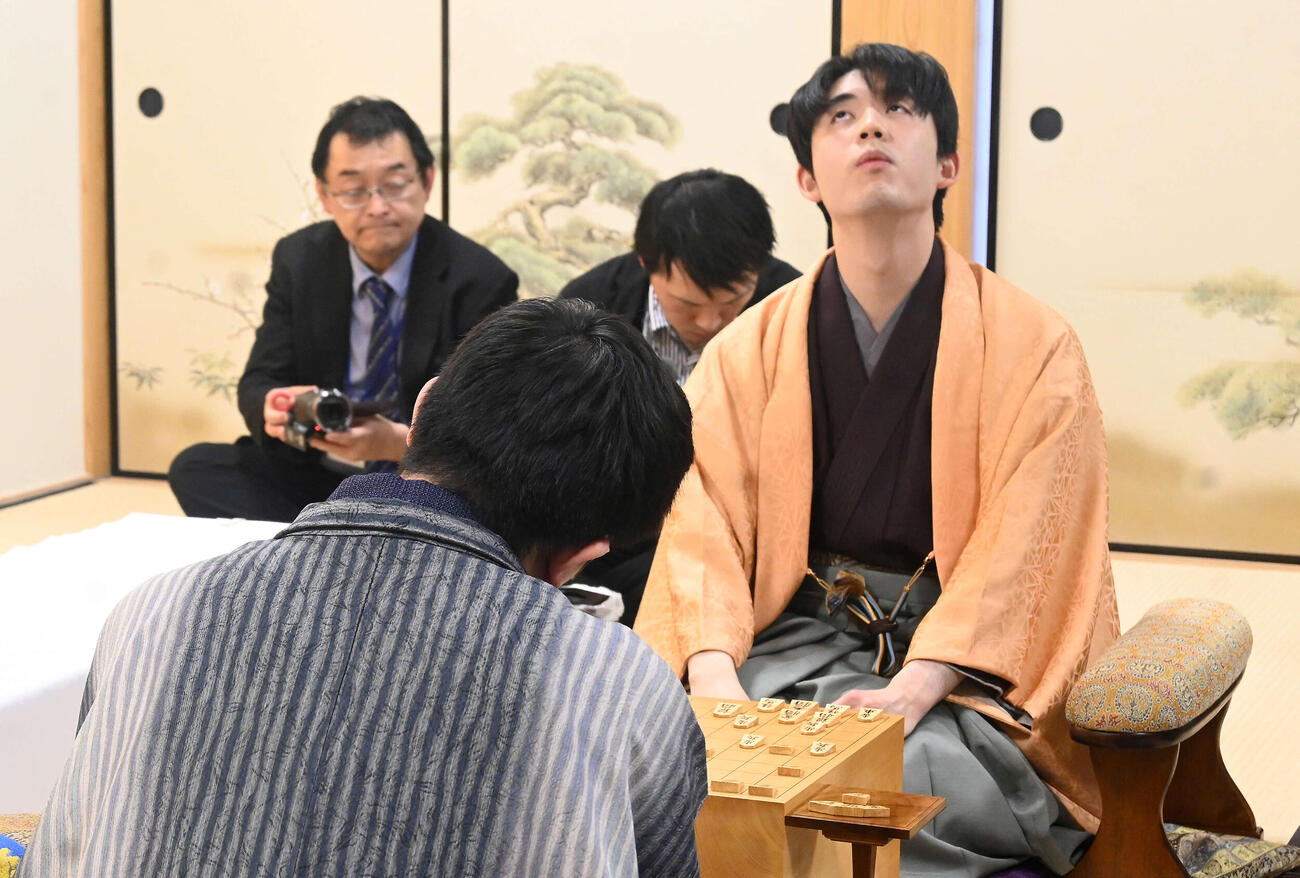 終局後、インタビューに応じる藤井聡太王将。手前は永瀬拓矢九段（撮影・松浦隆司）