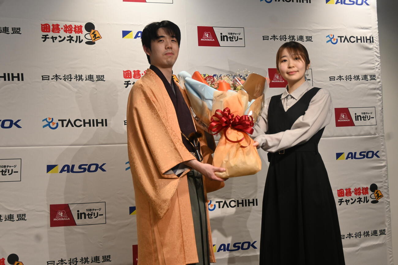 記者会見前に花束を贈られた藤井聡太王将（撮影・松浦隆司）