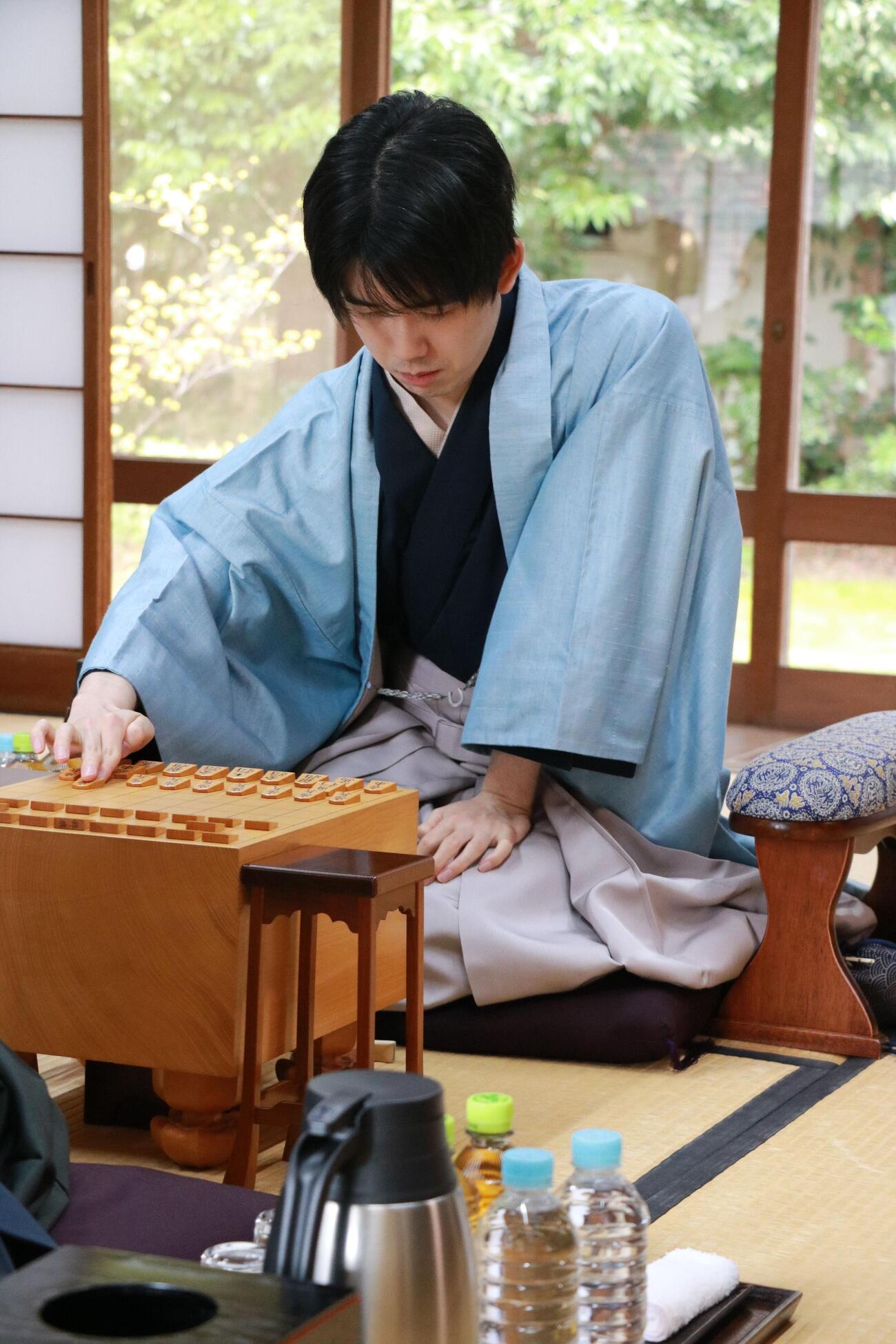 棋王戦5番勝負第5局で初手を指す藤井聡太棋王（日本将棋連盟提供）