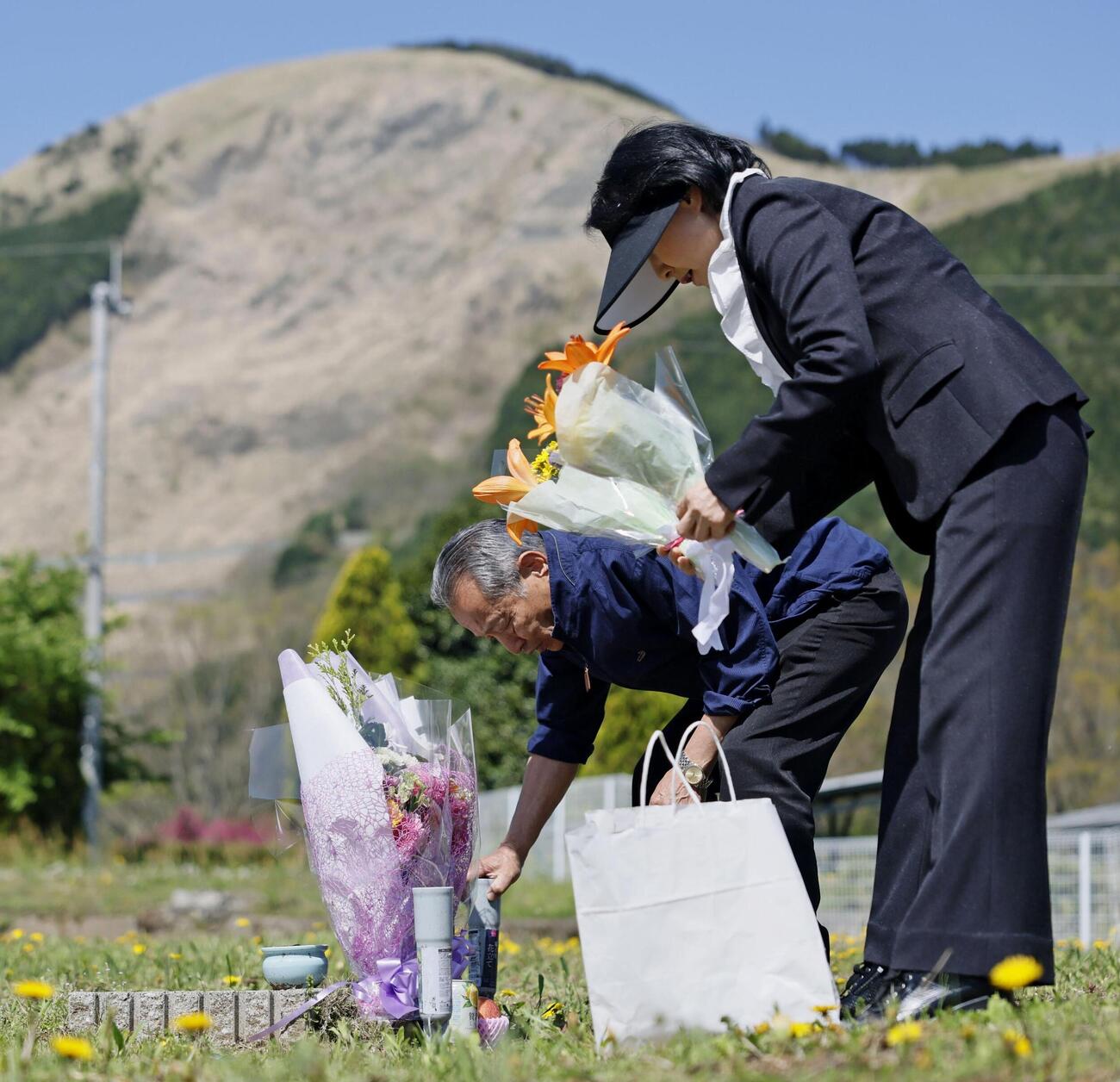 熊本地震の「本震」から10年となり、東海大生が亡くなったアパートの跡地を訪れ、花を手向ける元大家の渡辺武さん（左・79）と妻すま子さん（75）（共同）