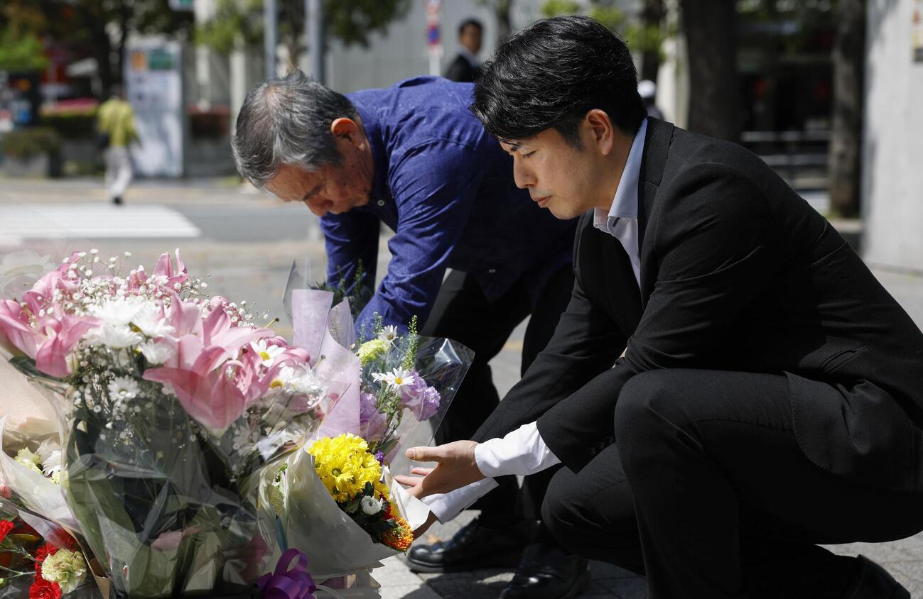 乗用車暴走事故から7年となり、慰霊碑に献花する松永拓也さん（右）と真菜さんの父上原義教さん（共同）