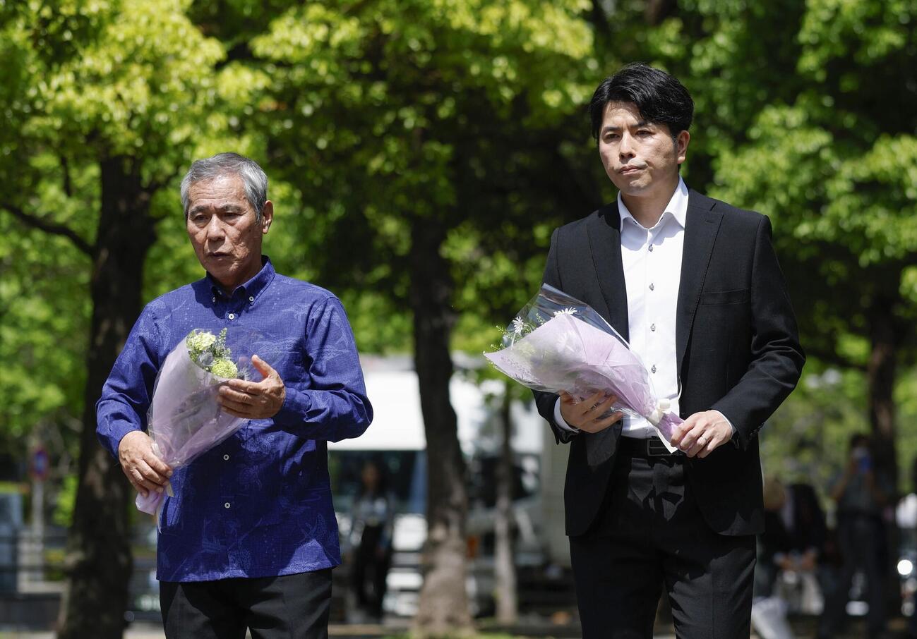 乗用車暴走事故から7年となり、献花へ向かう松永拓也さん（右）と真菜さんの父上原義教さん（共同）