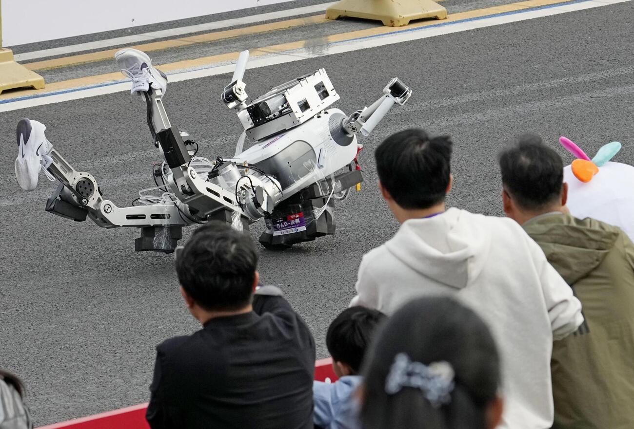 ハーフマラソン大会でスタート直後に転倒する人型ロボット（共同）