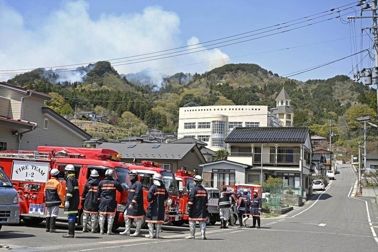 避難所となっている吉里吉里学園小学部（奥）近くから立ち上る煙(共同)