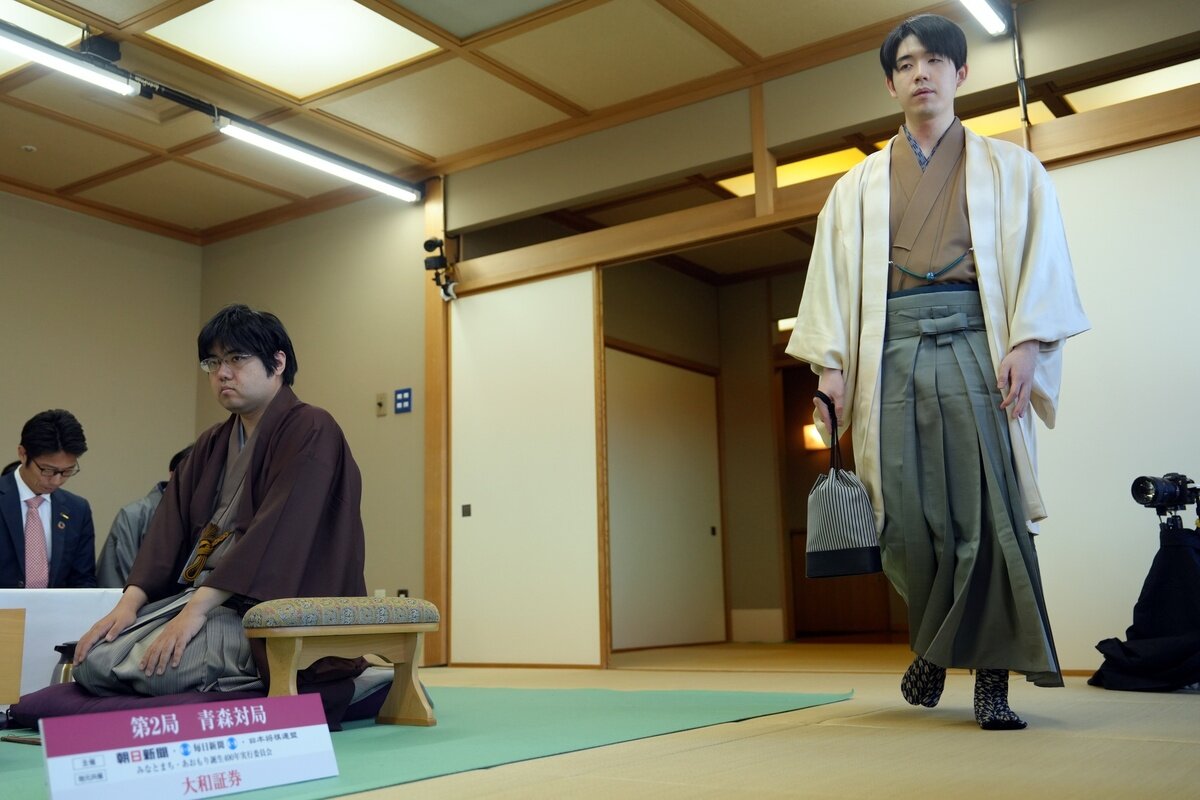 第2局の前に対局室に入室する藤井聡太名人（右）。左は挑戦者の糸谷哲郎九段（日本将棋連盟提供）