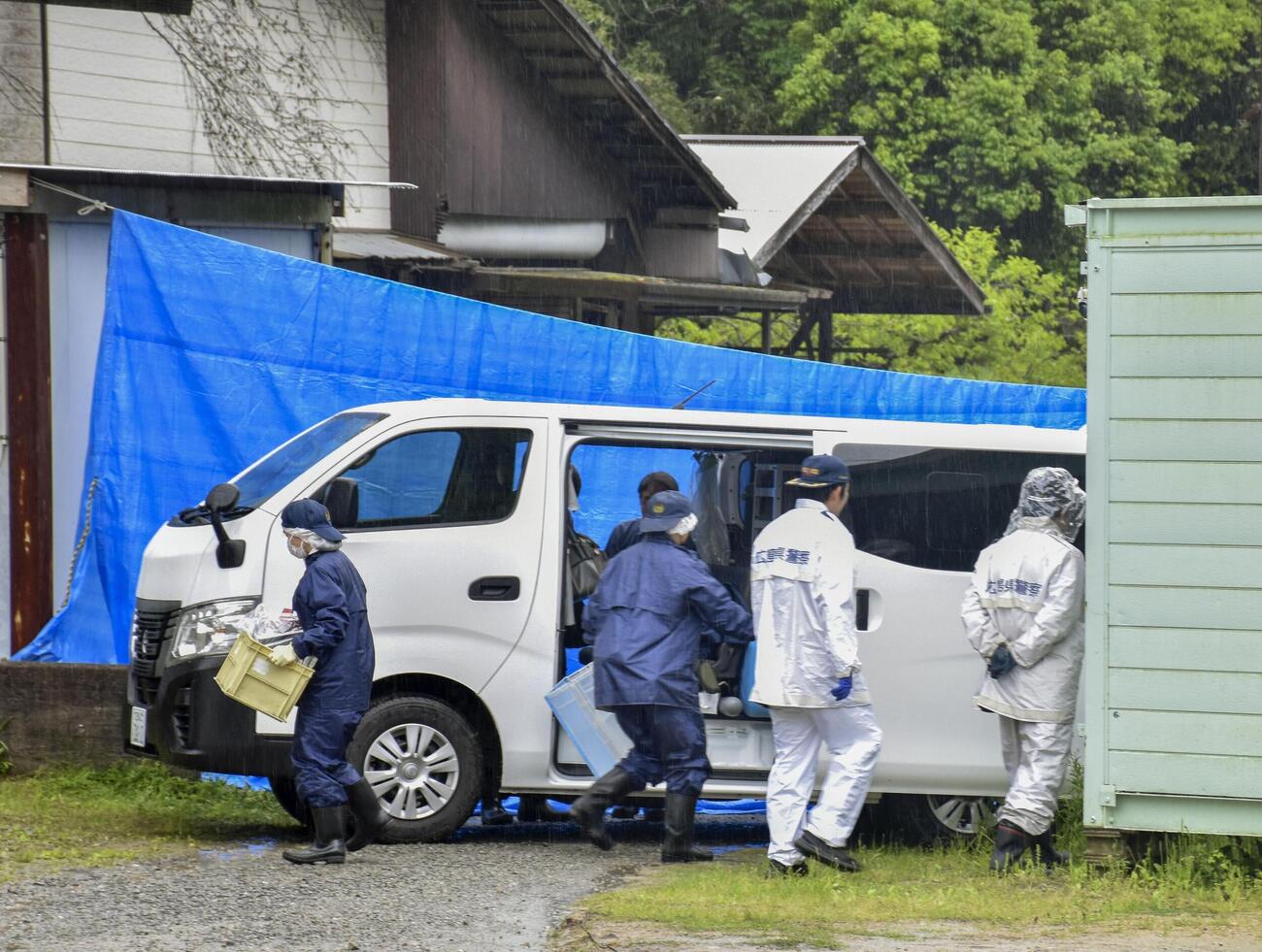 男性の遺体が見つかった広島県三原市の会社敷地内を現場検証する捜査員（共同）
