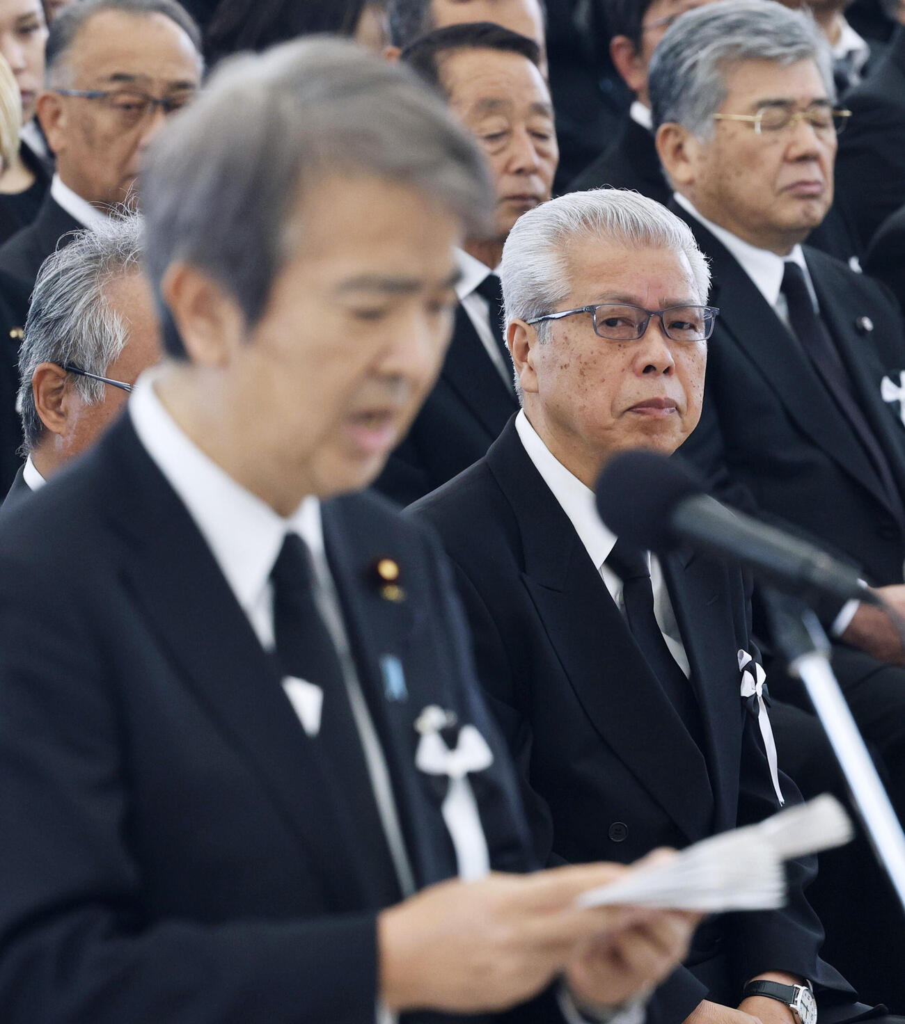 水俣病犠牲者慰霊式で「祈りの言葉」を読み上げる石原環境相（手前）を見つめる患者・遺族代表の緒方正実さん＝1日午後、熊本県水俣市（共同）