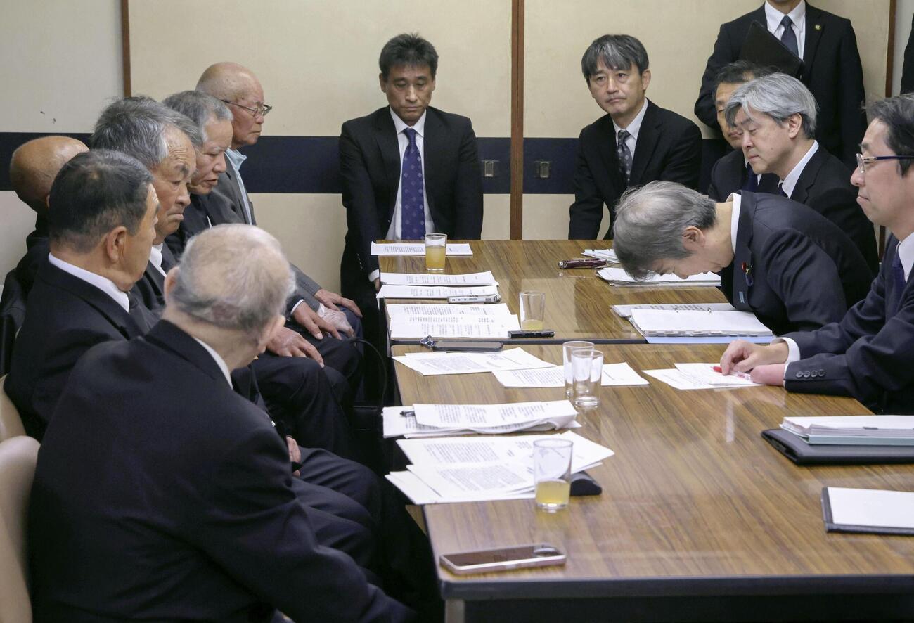 2年前の懇談で環境省職員が松崎重光さん（左手前）の発言を遮断した問題について謝罪する石原環境相＝1日午前、熊本県水俣市（代表撮影、共同）