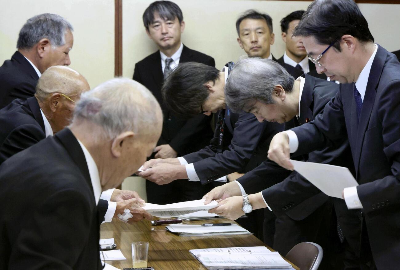 水俣病被害者団体から要望書を受け取る石原環境相（右手前から2人目）＝1日午前、熊本県水俣市（代表撮影、共同）