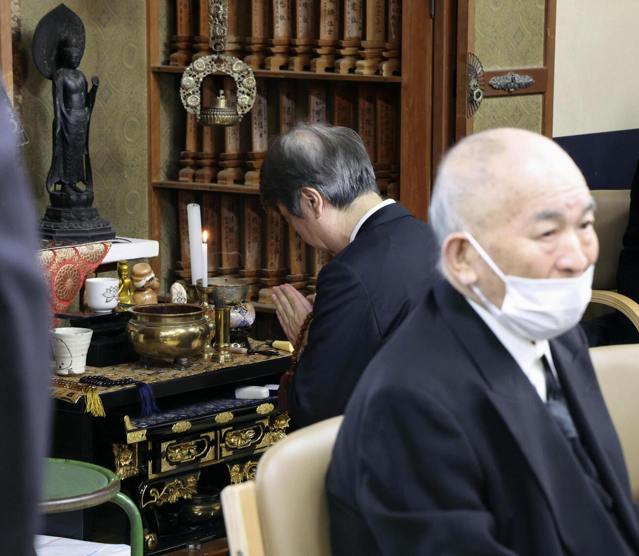 水俣病被害者の位牌が並ぶ仏壇に手を合わせる石原環境相。手前は松崎重光さん＝1日午前、熊本県水俣市（代表撮影、共同）