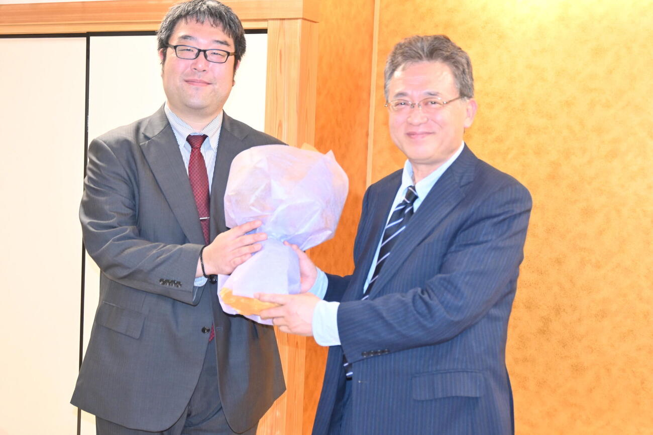 弟子の藤田一樹・指導棋士（左）に花束を贈られた脇謙二九段（撮影・松浦隆司）