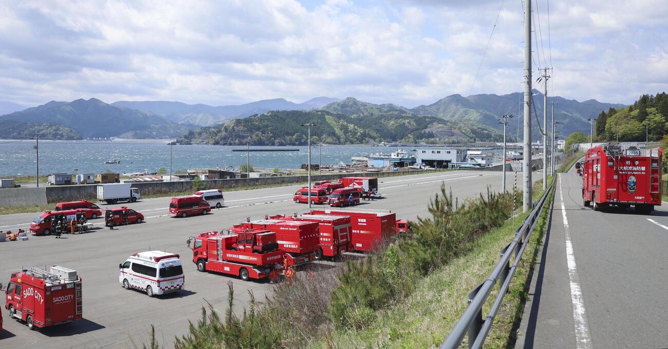 消防車両が並ぶ岩手県大槌町の港。山林火災の鎮圧が発表された＝2日午前(共同)