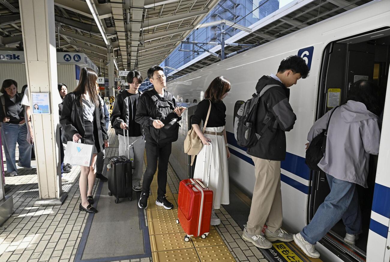 ゴールデンウイーク後半の5連休初日を迎え、東海道新幹線に乗り込む人たち（共同）