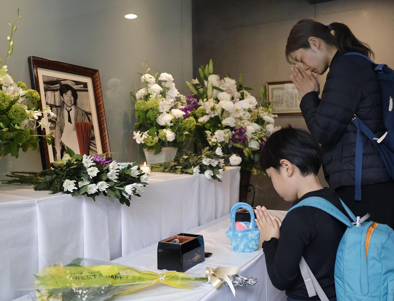 朝日新聞阪神支局に設けられた拝礼所で、小尻知博記者の遺影に向かって手を合わせる人たち＝3日午前、兵庫県西宮市(共同)