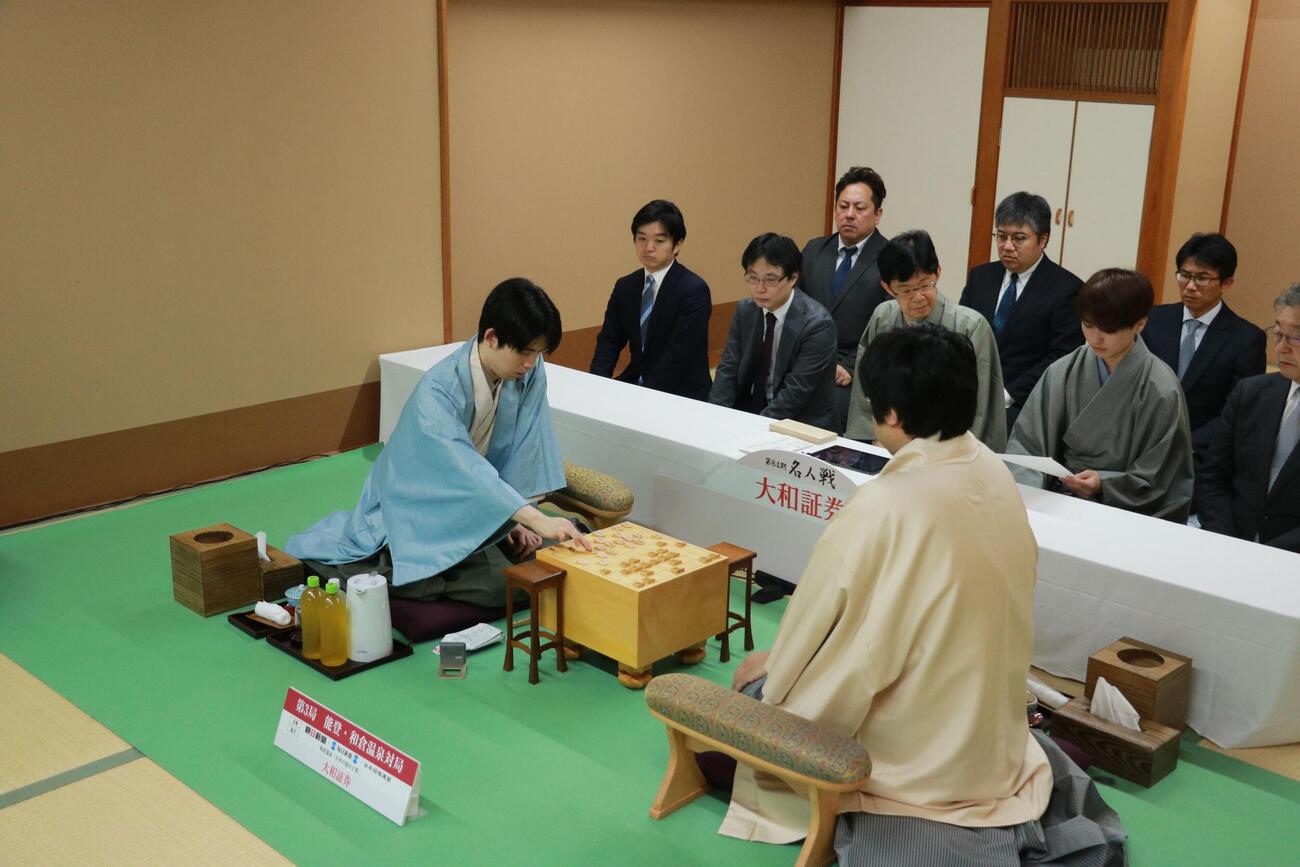 名人戦7番勝負第3局2日目、記録係が読み上げる前日の手順を盤上に再現する藤井聡太名人（左）、糸谷哲郎九段（日本将棋連盟提供）ふ