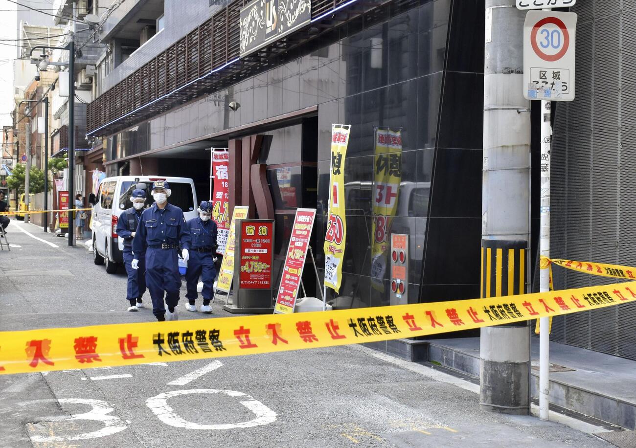 女性の遺体が見つかった現場付近を調べる大阪府警の捜査員（共同）