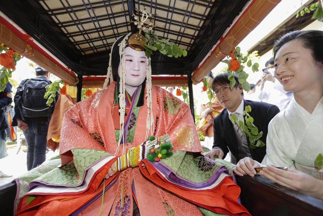 色鮮やかな平安装束姿でこしに乗り込む葵祭のヒロイン「斎王代」の塩見真桜さん＝15日午前、京都市