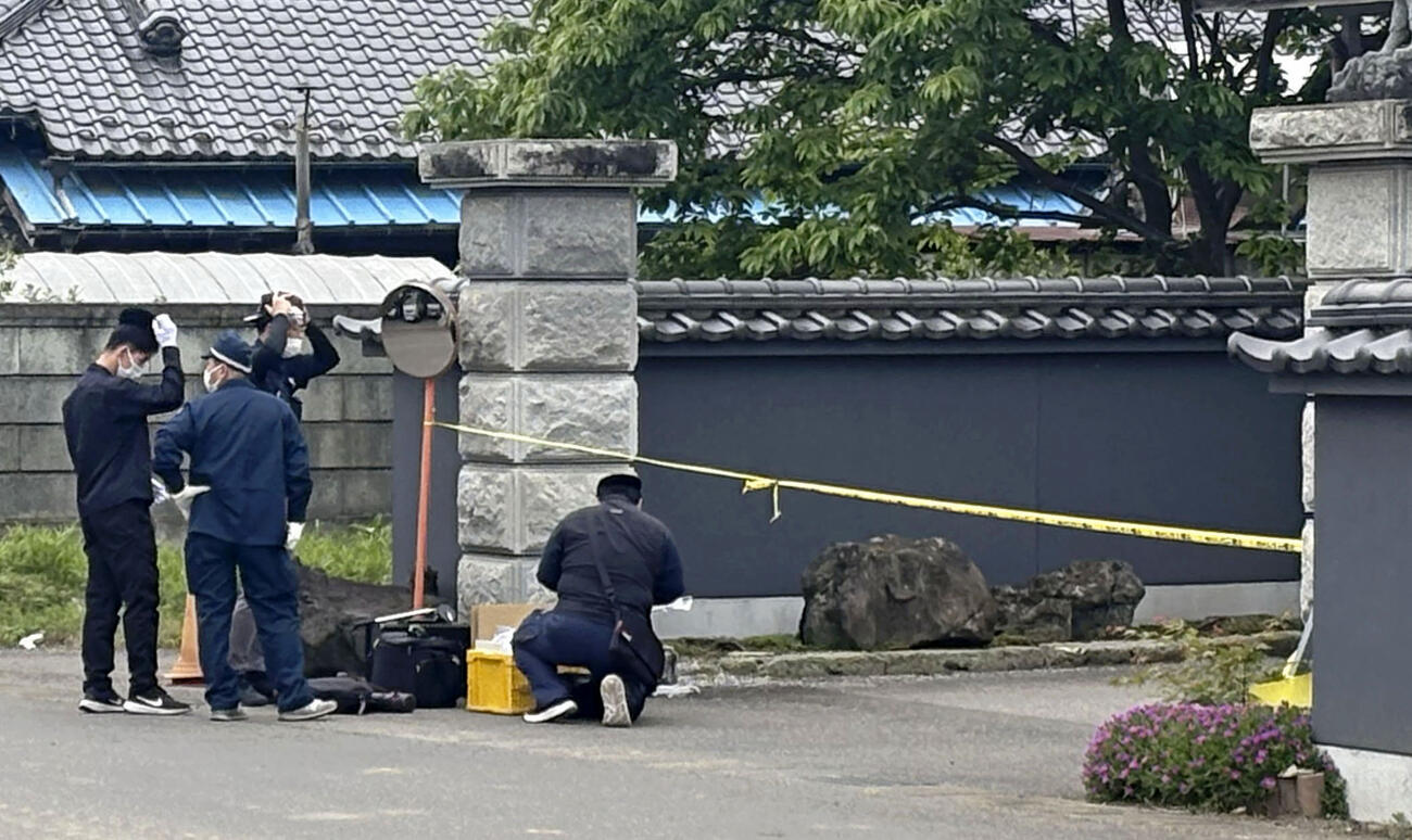 強盗殺人事件があった富山英子さんの住宅前に集まった捜査関係者＝15日午前、栃木県上三川町