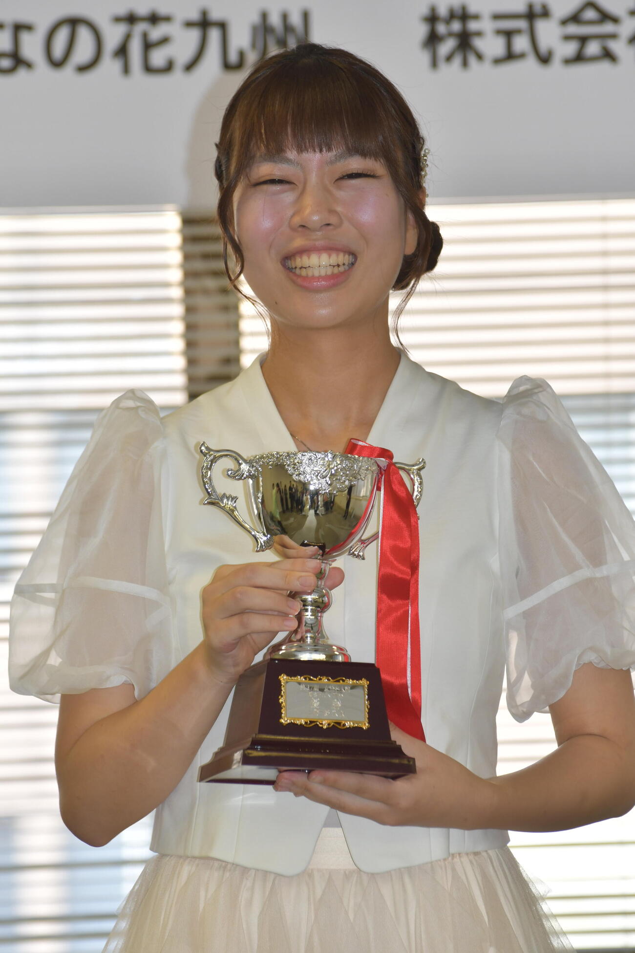 就位式でカップを手に笑顔を見せる上野愛咲美女流名人