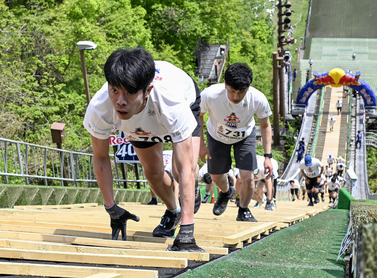 スキージャンプ台を駆け上がる人たち（共同）