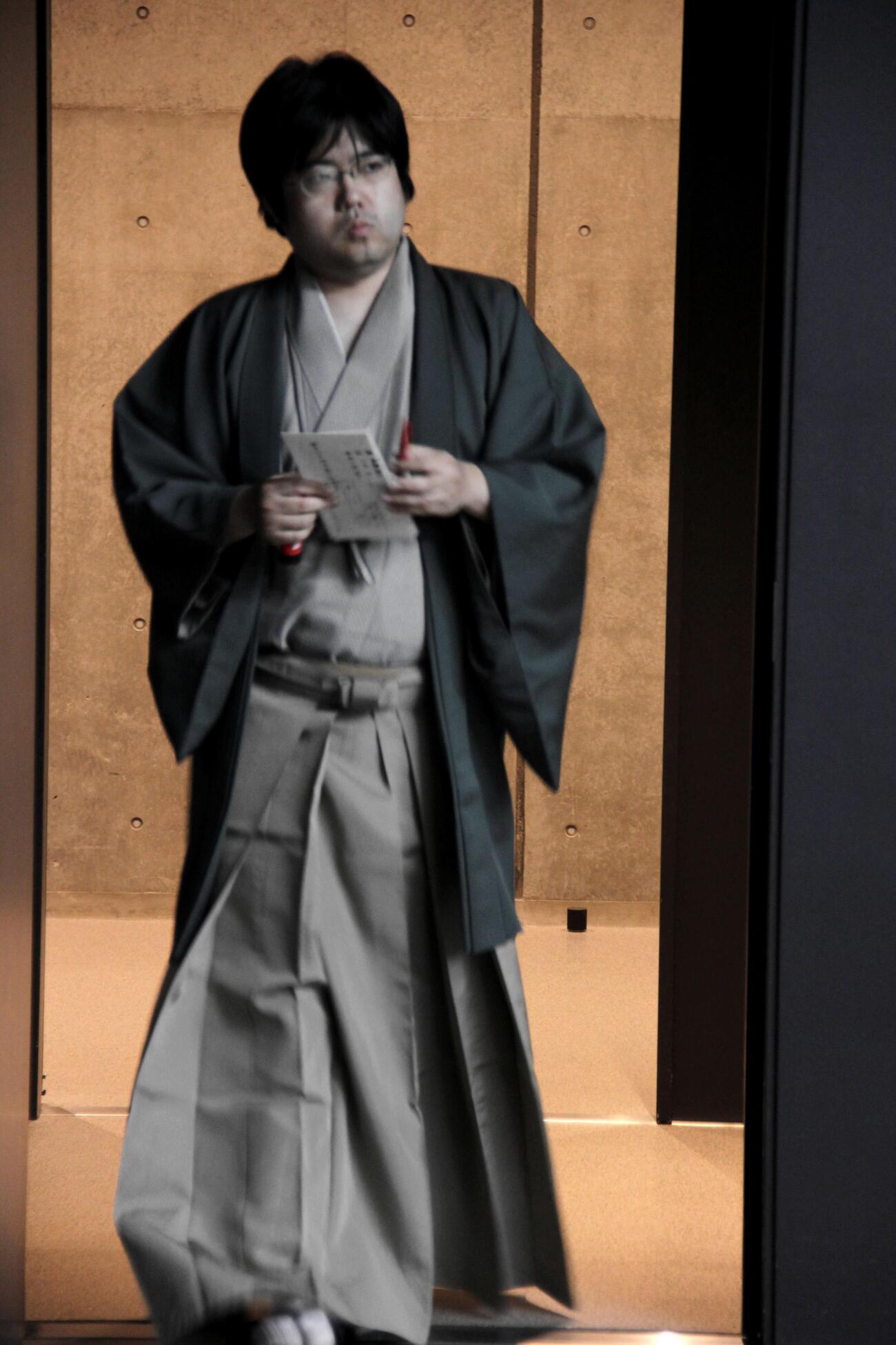 封じ手の封筒を持ち、対局場に再入室する糸谷哲郎九段（日本将棋連盟提供）