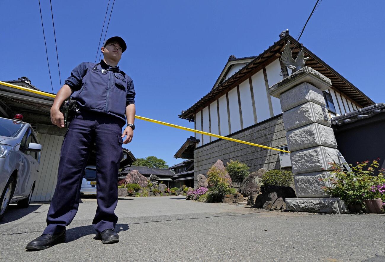 強盗殺人事件現場の住宅を警戒する警察官＝17日午前9時38分、栃木県上三川町(共同)