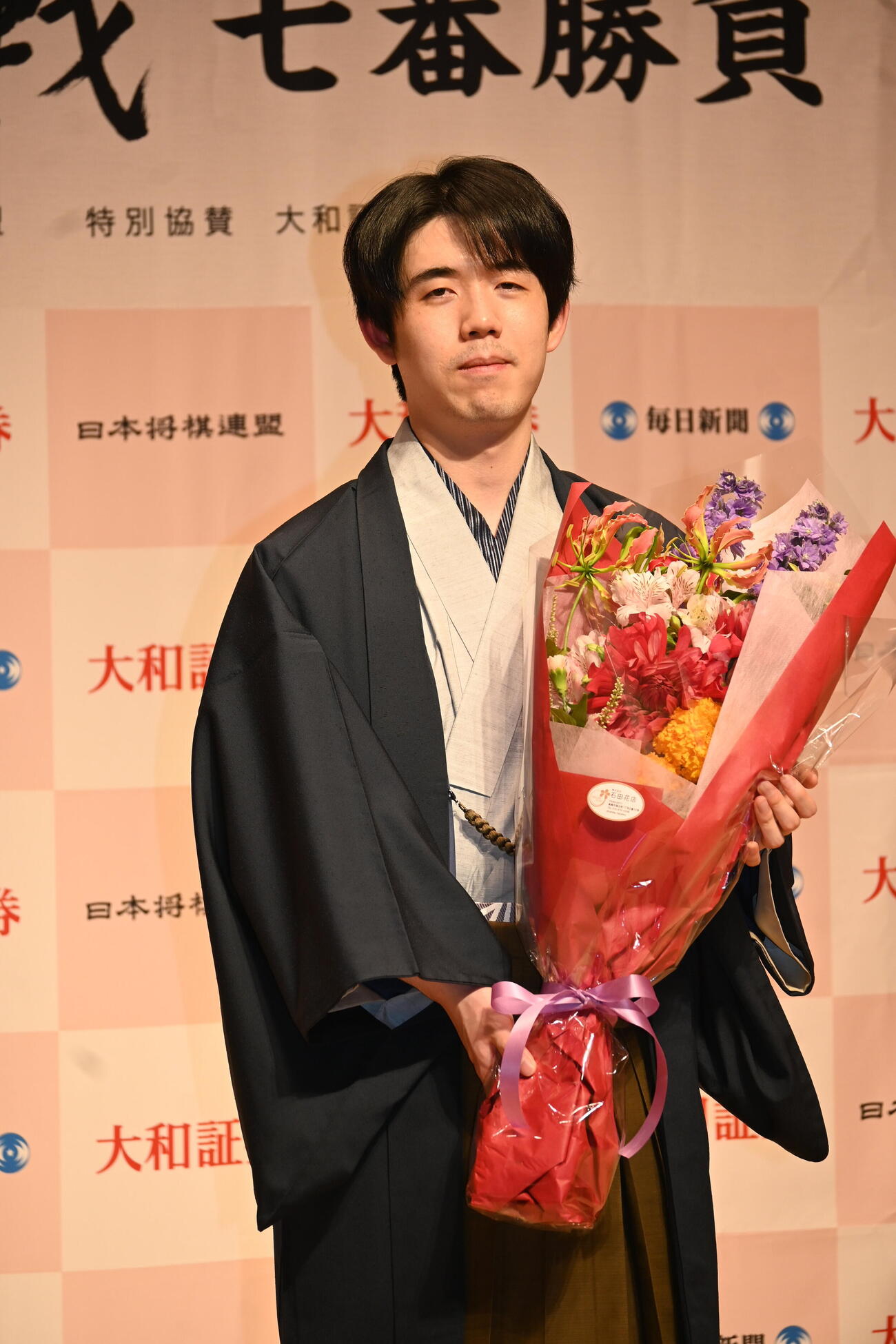 記者会見で花束を贈呈された藤井聡太名人（撮影・松浦隆司）