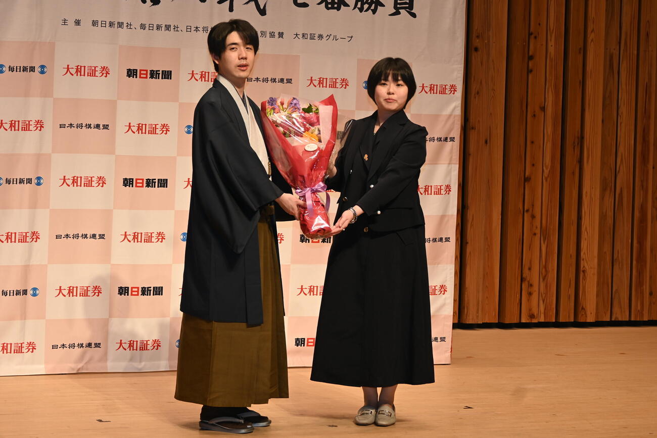記者会見で花束を贈呈された藤井聡太名人（撮影・松浦隆司）