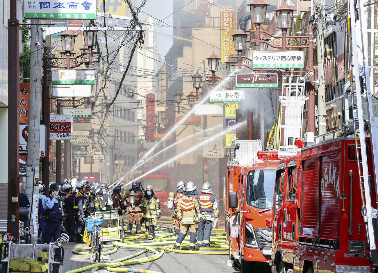 大阪市中央区の火災現場で、消火活動する消防隊員ら（共同）