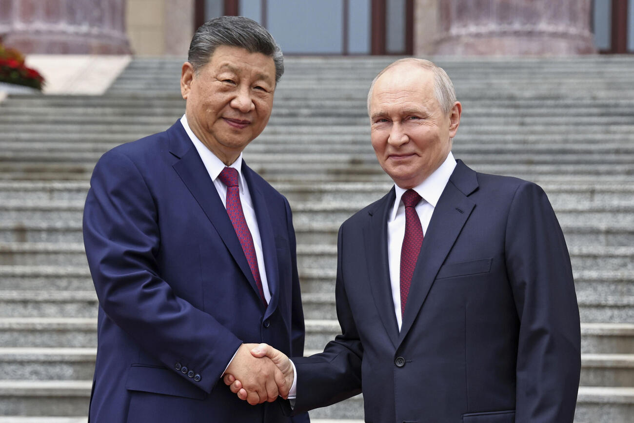 歓迎式典で握手するロシアのプーチン大統領（右）と中国の習近平国家主席（AP＝共同）