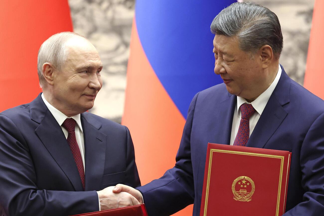 調印式で握手するロシアのプーチン大統領（左）と中国の習近平国家主席（共同）