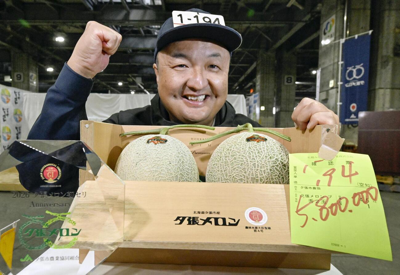 初競りで2玉580万円で落札された「夕張メロン」と「ふたみ青果」の大久保浩一営業統括本部長（共同）