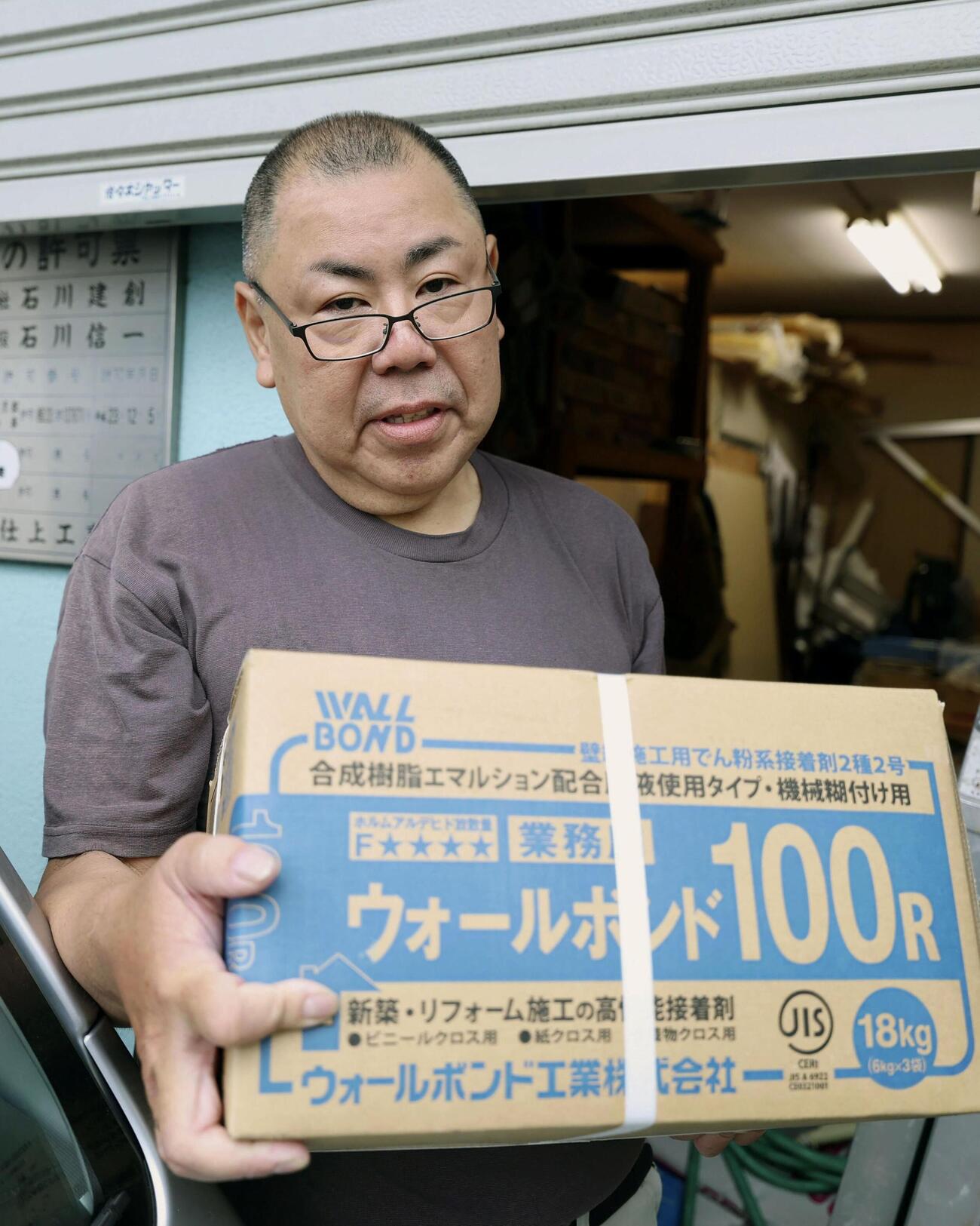 資材不足について話す石川信一さん＝21日、東京都北区(共同)