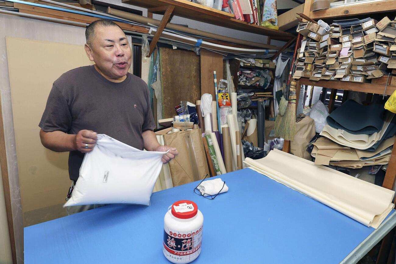 資材不足について話す石川信一さん＝21日、東京都北区(共同)