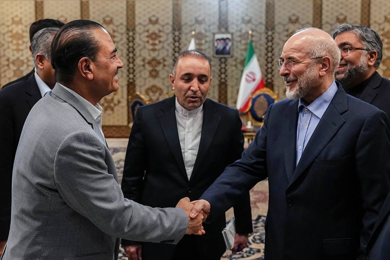 23日、イランの首都テヘランで、ガリバフ国会議長（右）と握手するパキスタンの軍トップ、ムニール陸軍元帥（イラン国会議長事務所提供・ゲッティ＝共同）