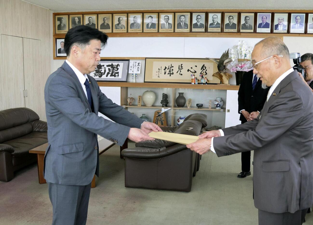 市議会議長に辞職届を提出する福岡県田川市の村上卓哉市長（左）＝25日午前、田川市役所（共同）
