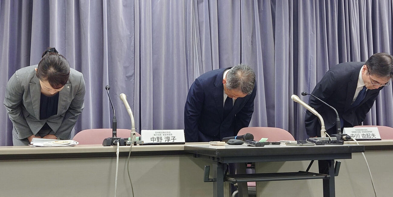 記者会見で謝罪する日航の中川由起夫常務（中央）ら（共同）