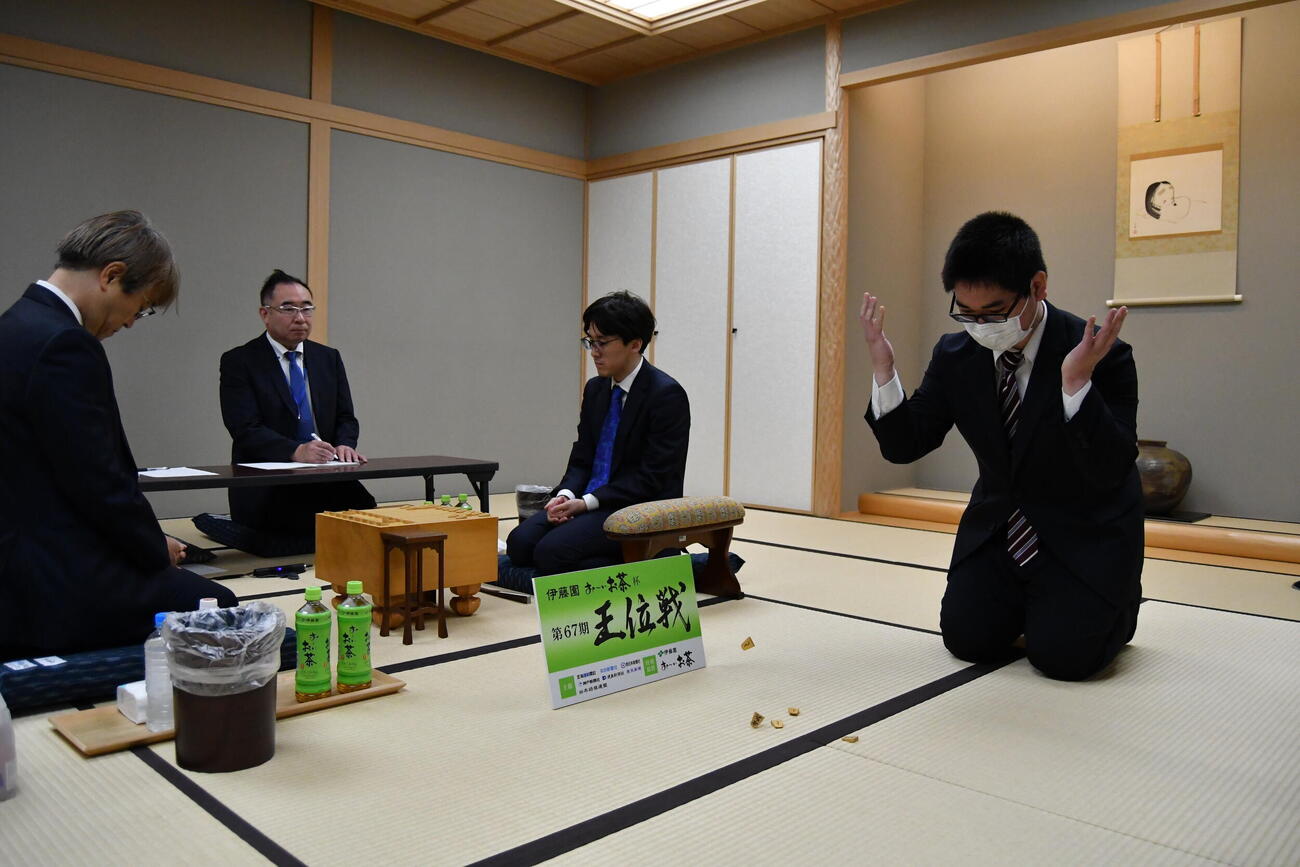 先手後手を決める振り駒はと金が3枚出て羽生善治九段（左）が先手