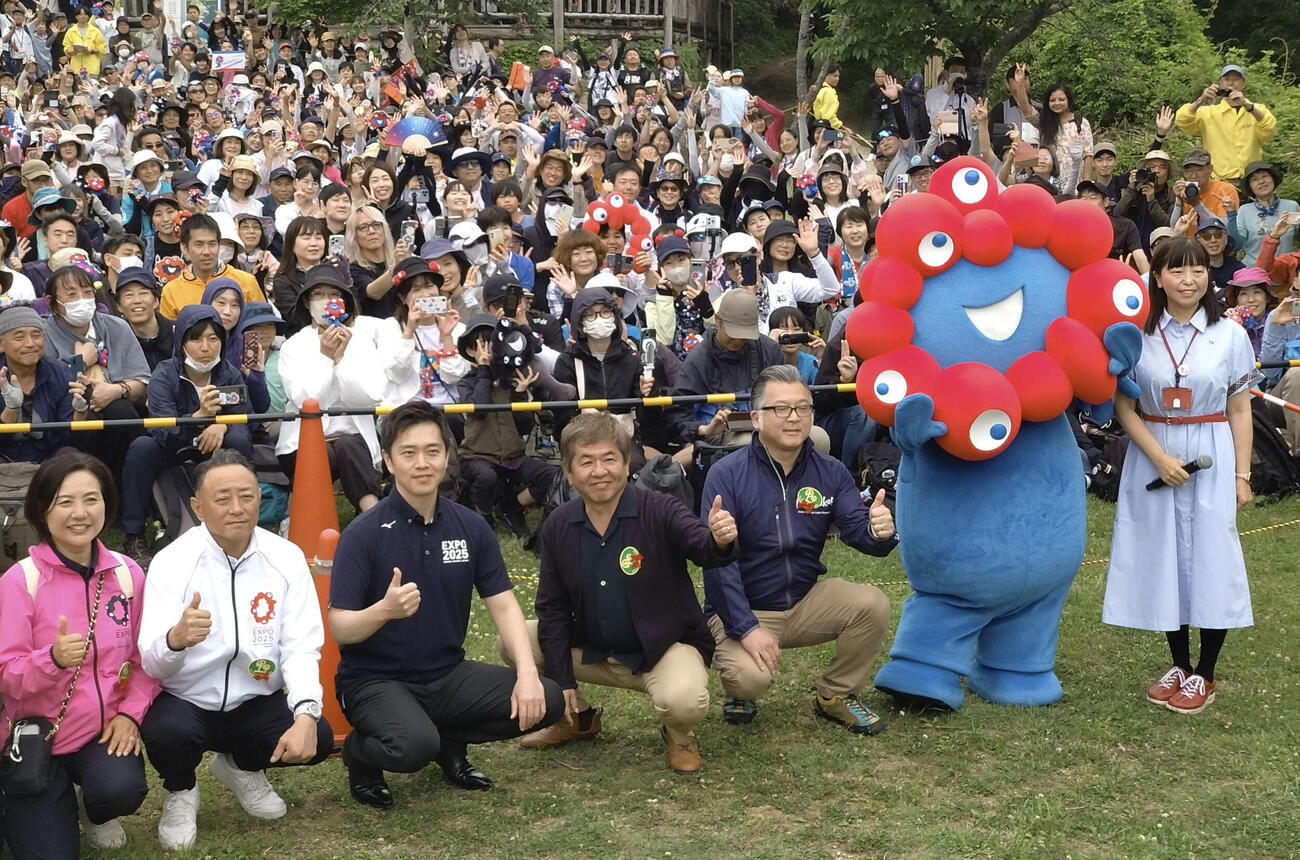 「ちはや園地」で開催された大阪・関西万博の振り返りイベントで、公式キャラクター「ミャクミャク」と写真に納まる参加者ら(共同)