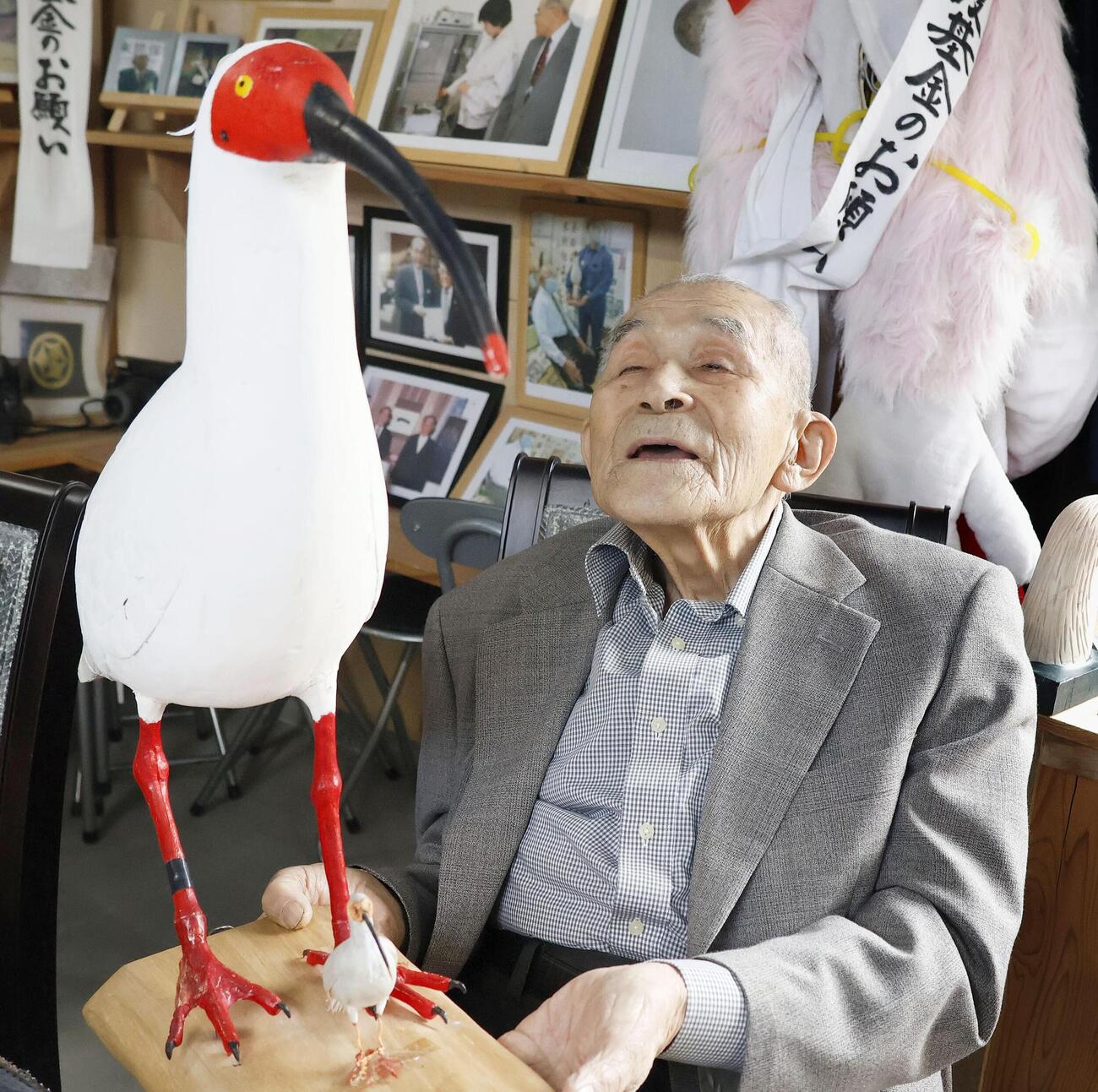 トキの模型を手に取材に応じる村本義雄さん＝4月、石川県羽咋市(共同)