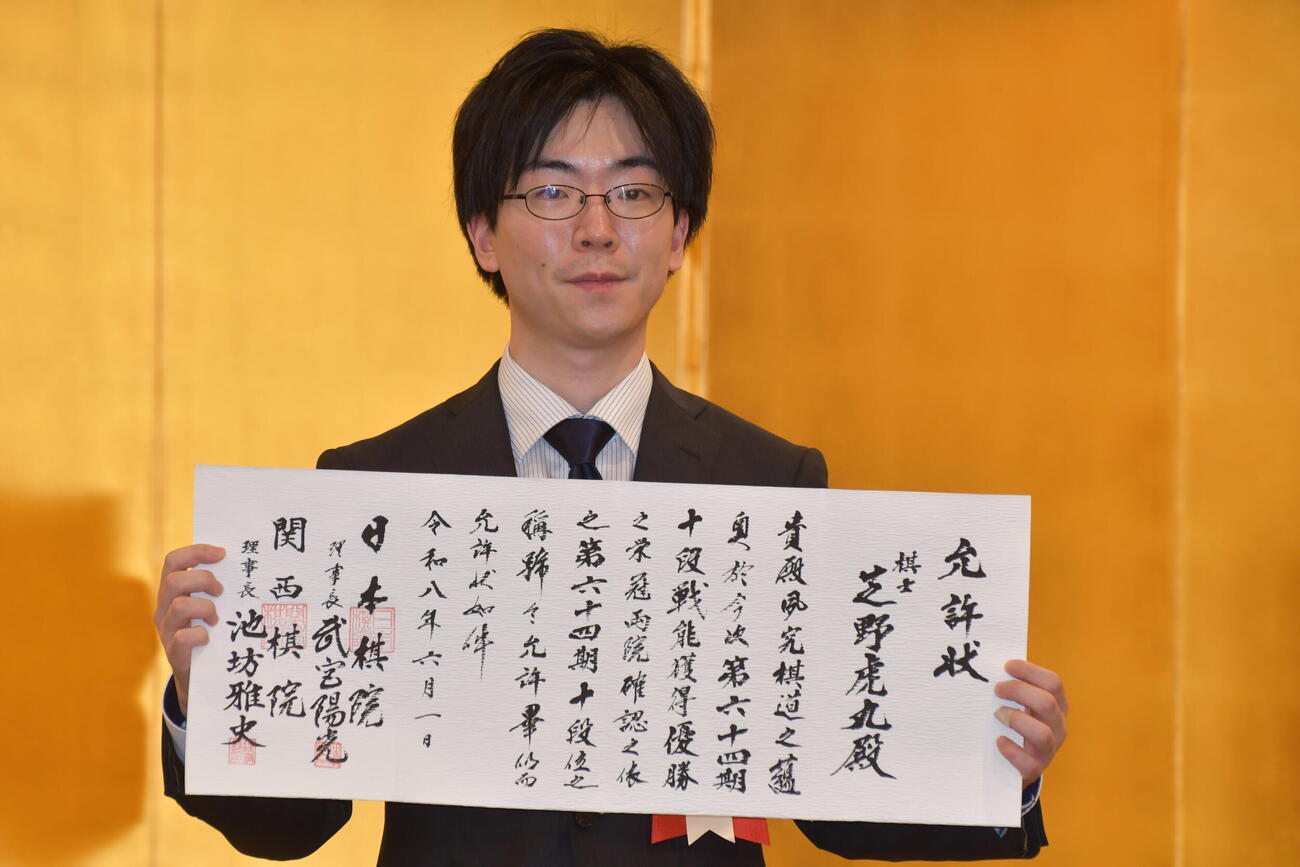 就位式で允許（いんきょ）状を手にする芝野虎丸十段